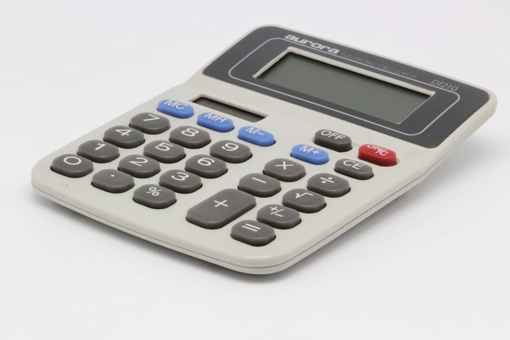 Calculatrice posée sur des documents pour estimer le déficit foncier