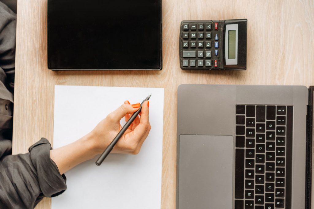 Épargnant calculant le rendement net de son placement après impôt avec une calculatrice