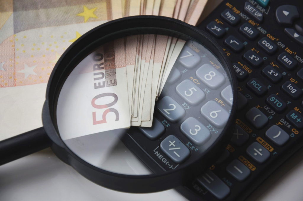Calcul du budget mensuel d'un volontaire avec une calculatrice et des euros