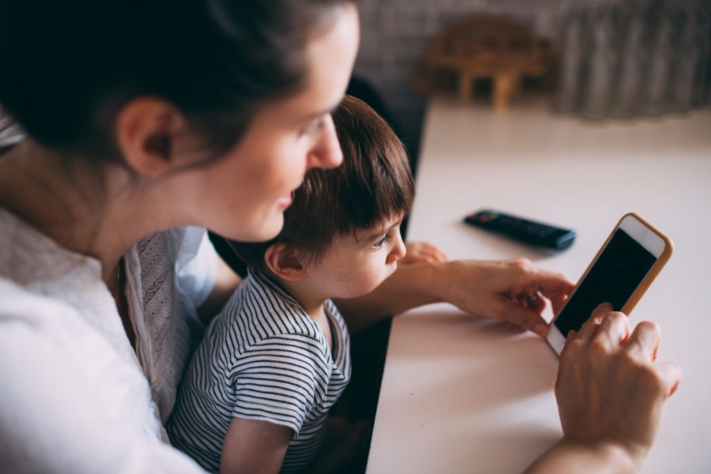 Parent utilisant une application pour nounou sur son smartphone