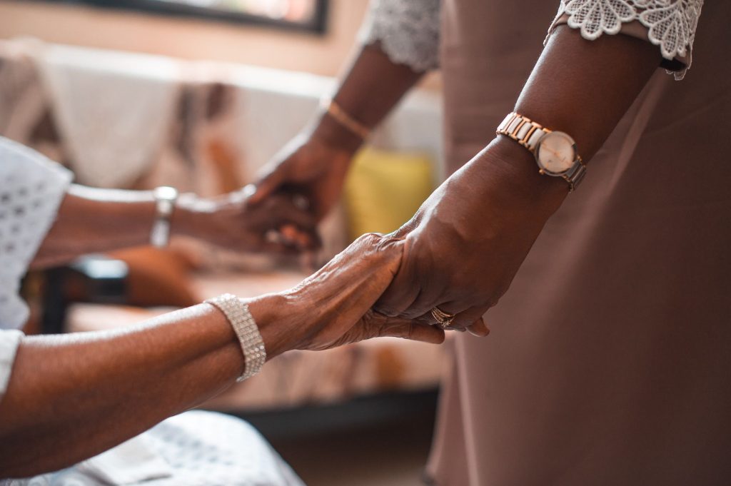 Mains d’une personne âgée accompagnée d’un proche lors de démarches successorales