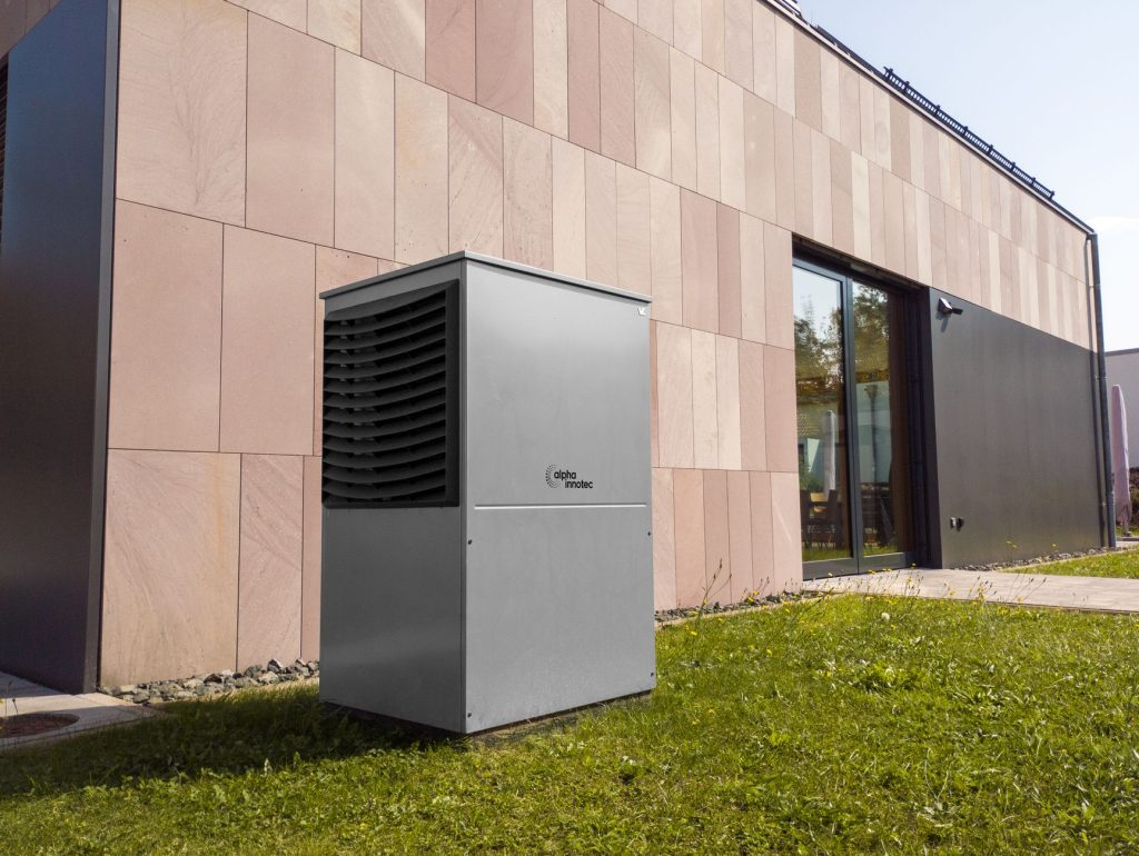 Unité extérieure d'une pompe à chaleur air-eau installée contre la façade d'une maison individuelle