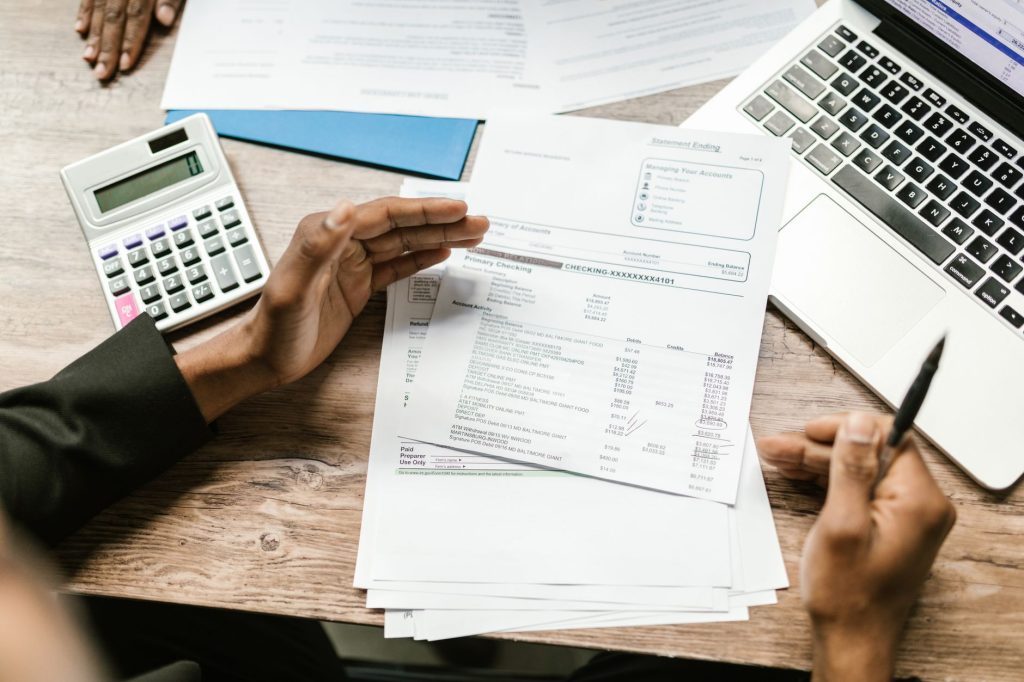 Relevés de compte bancaire et documents financiers étalés sur un bureau après un décès