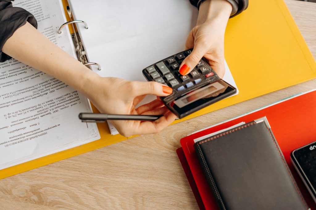 Documents comptables et calculatrice sur le bureau d’un travailleur indépendant