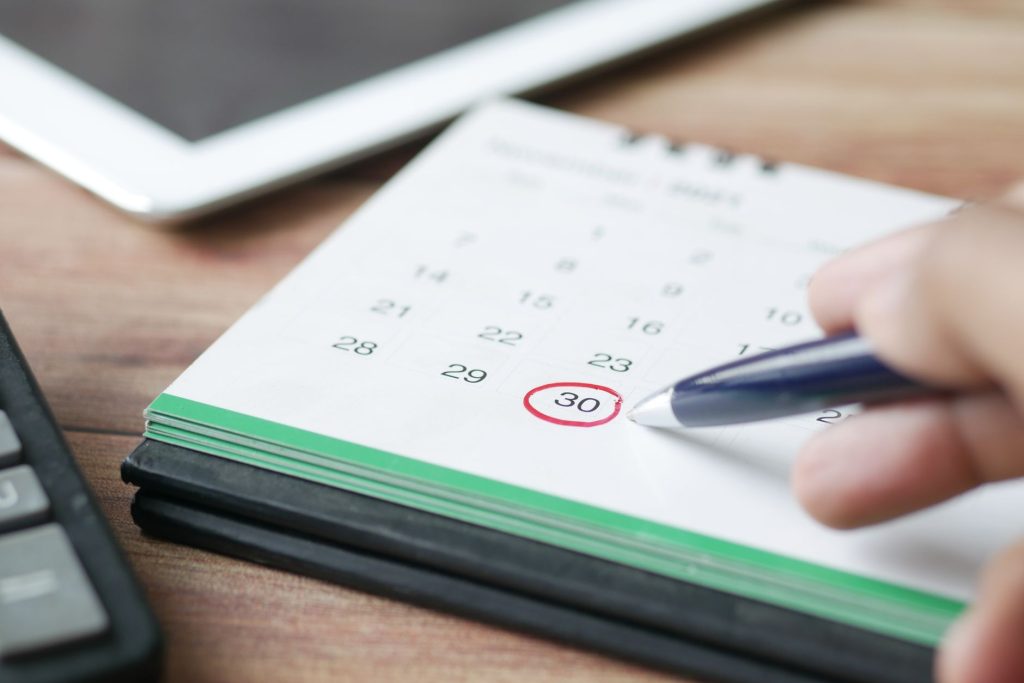 Calendrier et agenda ouverts sur un bureau illustrant les délais de la succession