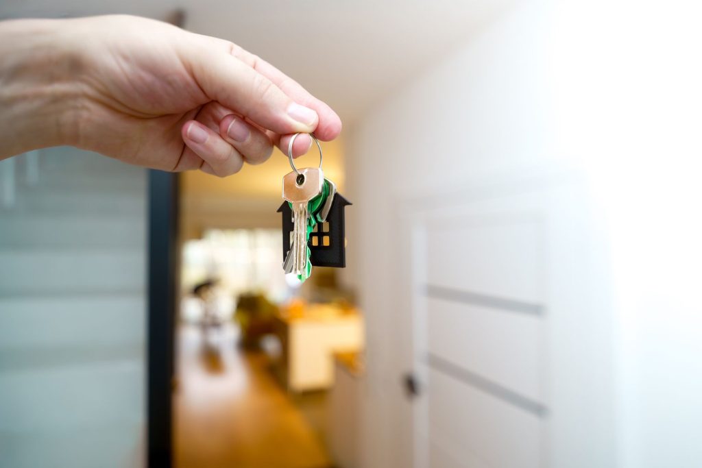 Femme senior tenant les clés de son logement après une succession