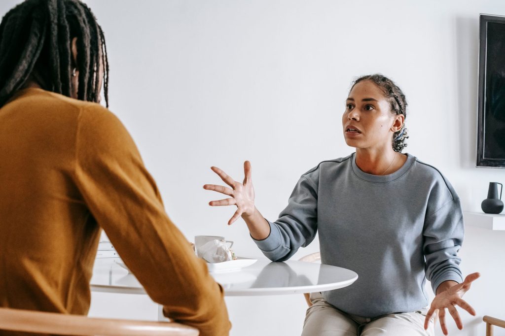 Discussion tendue entre héritiers autour d’une table lors du règlement d’une succession
