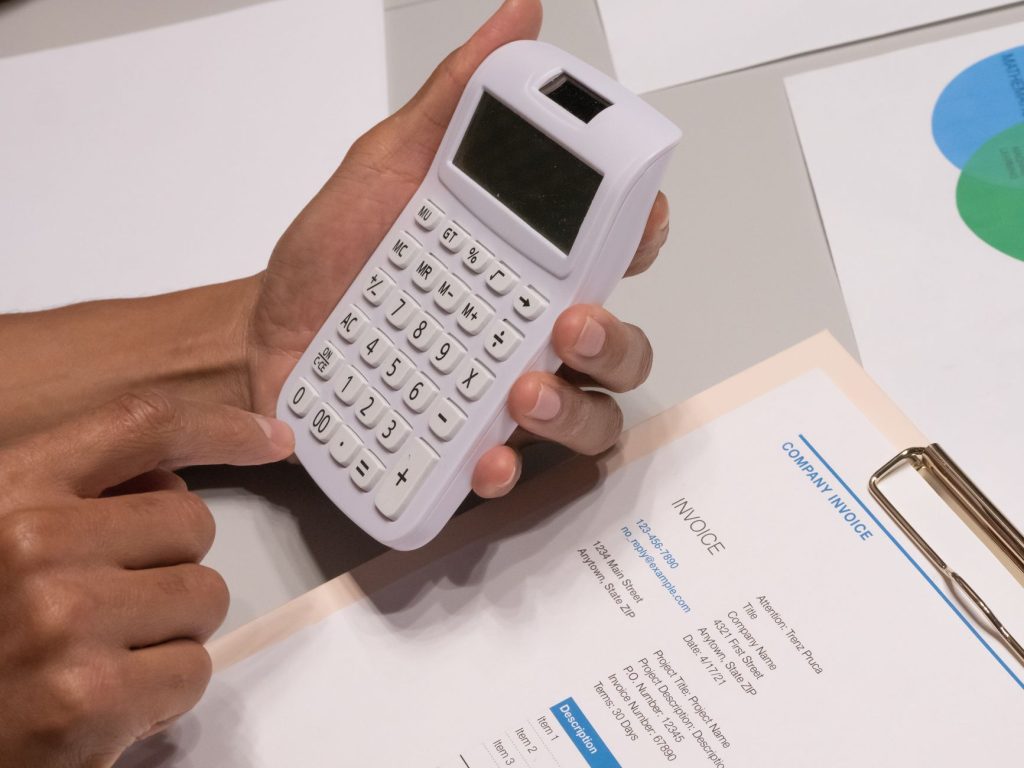 Indépendant calculant ses cotisations sociales et ses droits à la retraite sur un bureau avec calculatrice et documents