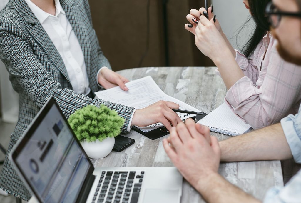 Couple signant un contrat de prêt immobilier avec un conseiller bancaire