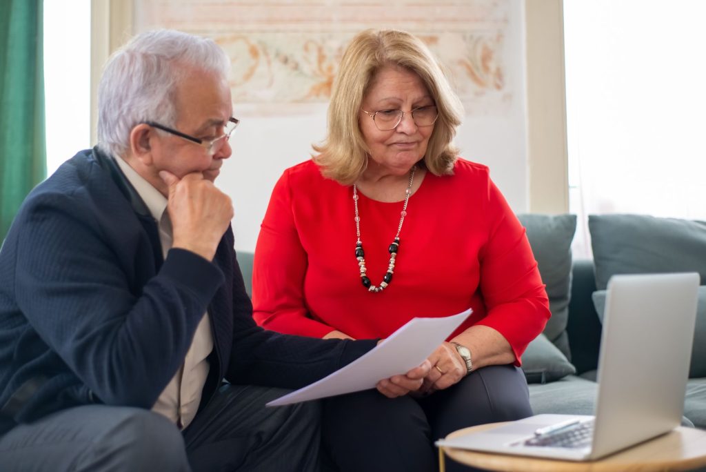 Couple de seniors examinant des documents patrimoniaux et successoraux