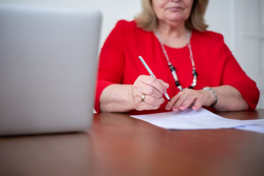 Personne âgée remplissant un formulaire de demande d'ASPA à son bureau